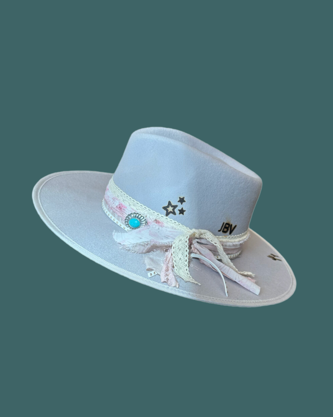 Grey Western Cowgirl Hat with Bands and Ribbons on a Teal Background.